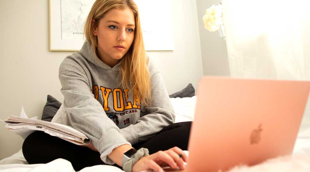 Loyola University Chicago student studies in her dorm room
