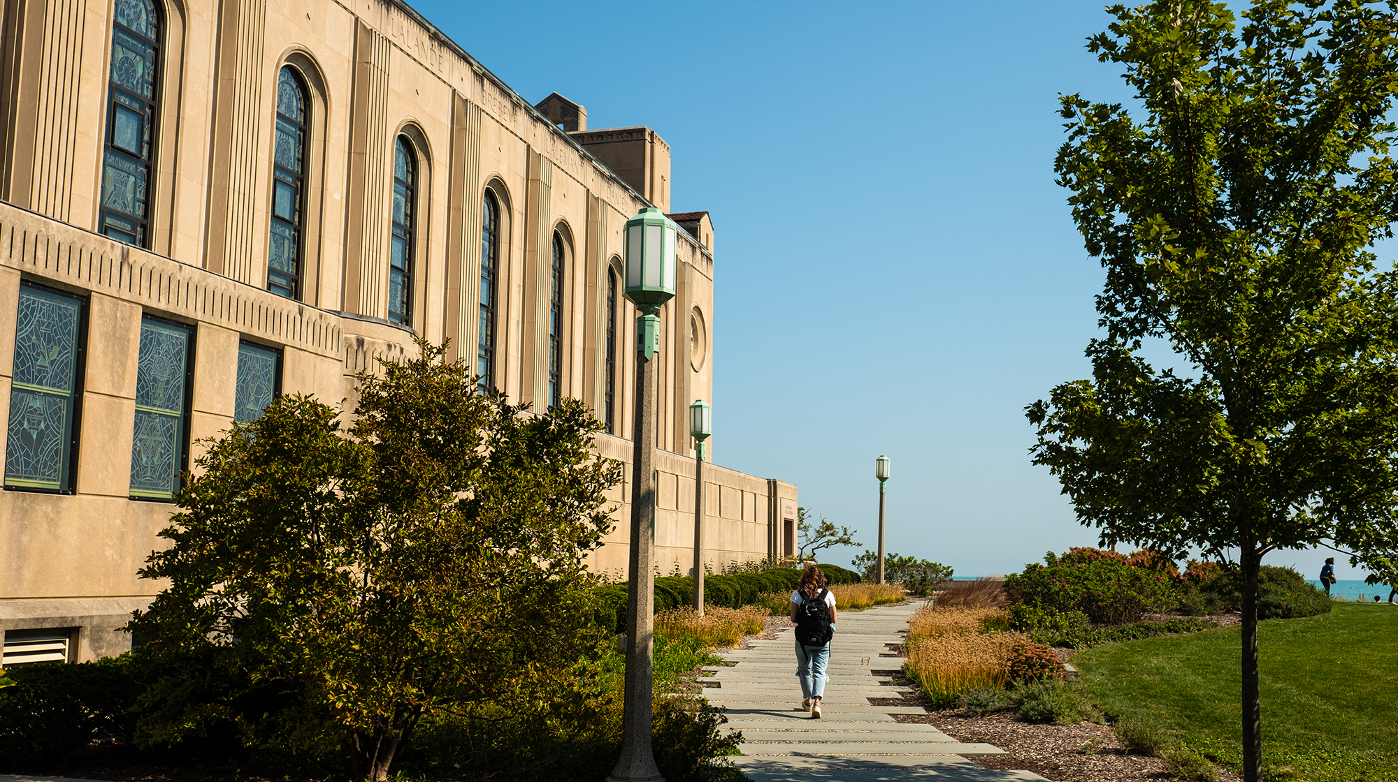 A student goes for a walk on campus by the lake A student goes for a walk on campus by the lake