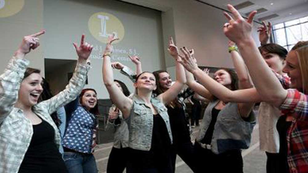 A group of students with their hands in the air performing a group programming excercise A group of students with their hands in the air performing a group programming excercise