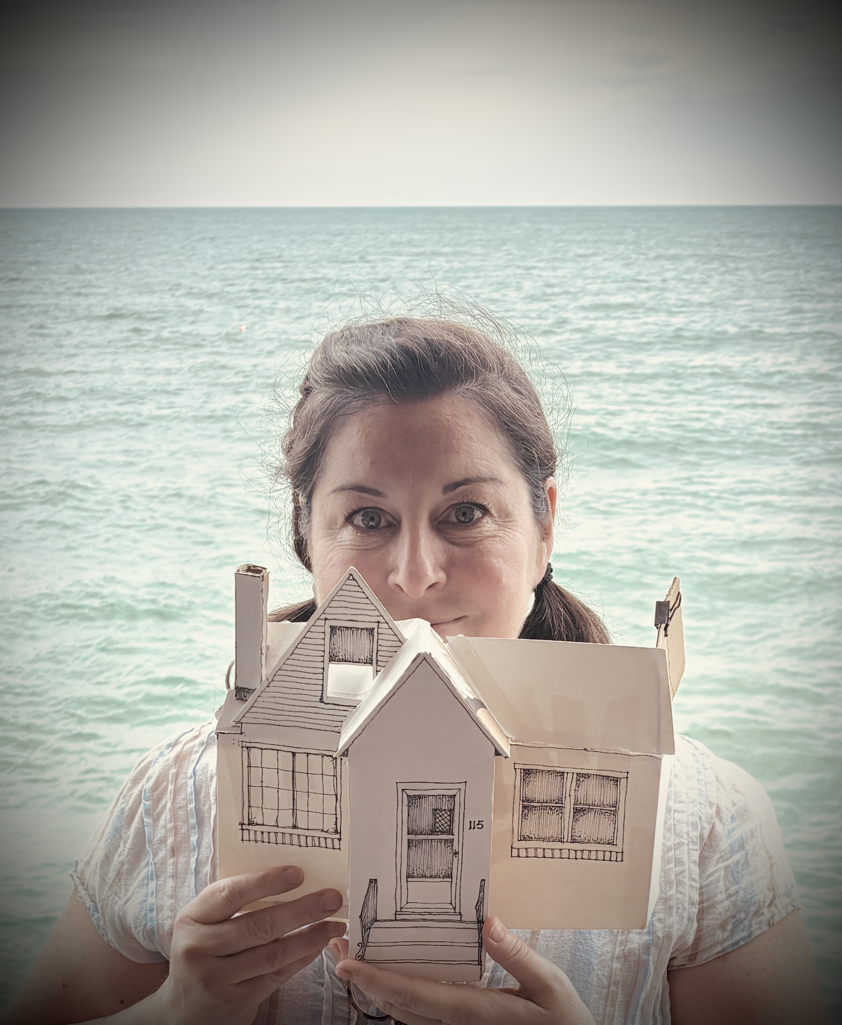 Loyola Faculty Member Rachel Healy holding a prop house Loyola Faculty Member Rachel Healy holding a prop house