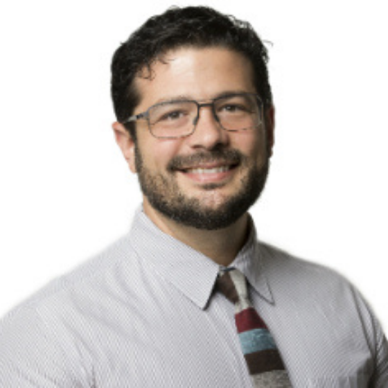 Smiling man with short brown hair, wearing glasses and a striped tie, against a solid white background. Smiling man with short brown hair, wearing glasses and a striped tie, against a solid white background.