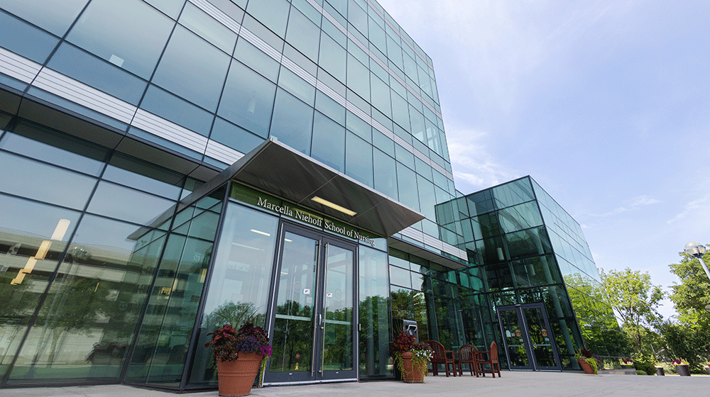 The Marcella Niehoff School of Nursing sign above the entrance of the school's glass exterior building at the Health Sciences Campus on a sunny day The Marcella Niehoff School of Nursing sign above the entrance of the school's glass exterior building at the Health Sciences Campus on a sunny day