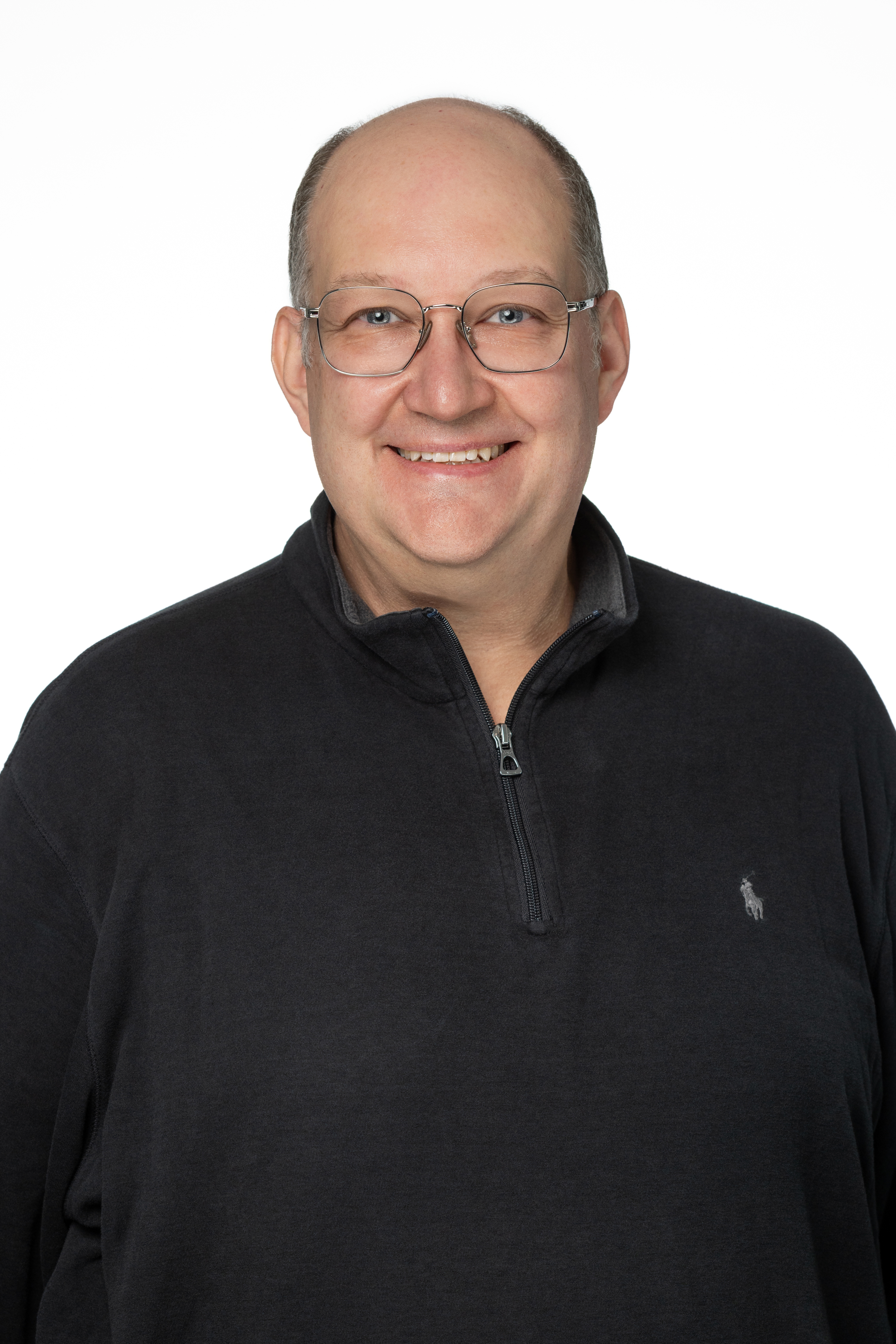 Nathan H. Perkins, a man with glasses and a bald head, wearing a dark quarter-zip pullover, smiling against a light gray background. Nathan H. Perkins, a man with glasses and a bald head, wearing a dark quarter-zip pullover, smiling against a light gray background.