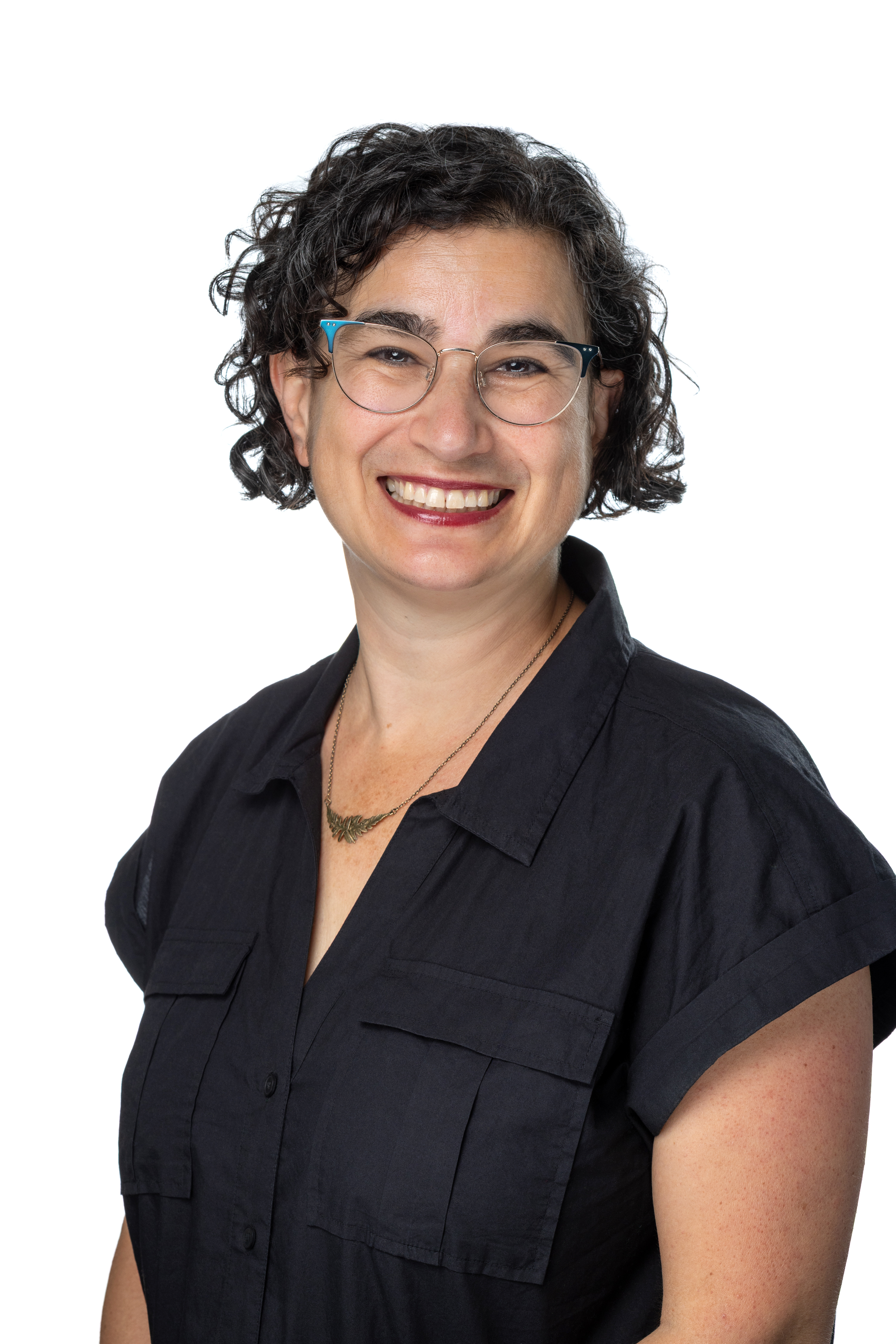 Sarah Lieberman Weisz, Director of Faculty Grants and Scholarship, smiling with short curly dark hair and glasses, wearing a navy short-sleeve blouse and a delicate necklace against a light background. Sarah Lieberman Weisz, Director of Faculty Grants and Scholarship, smiling with short curly dark hair and glasses, wearing a navy short-sleeve blouse and a delicate necklace against a light background.