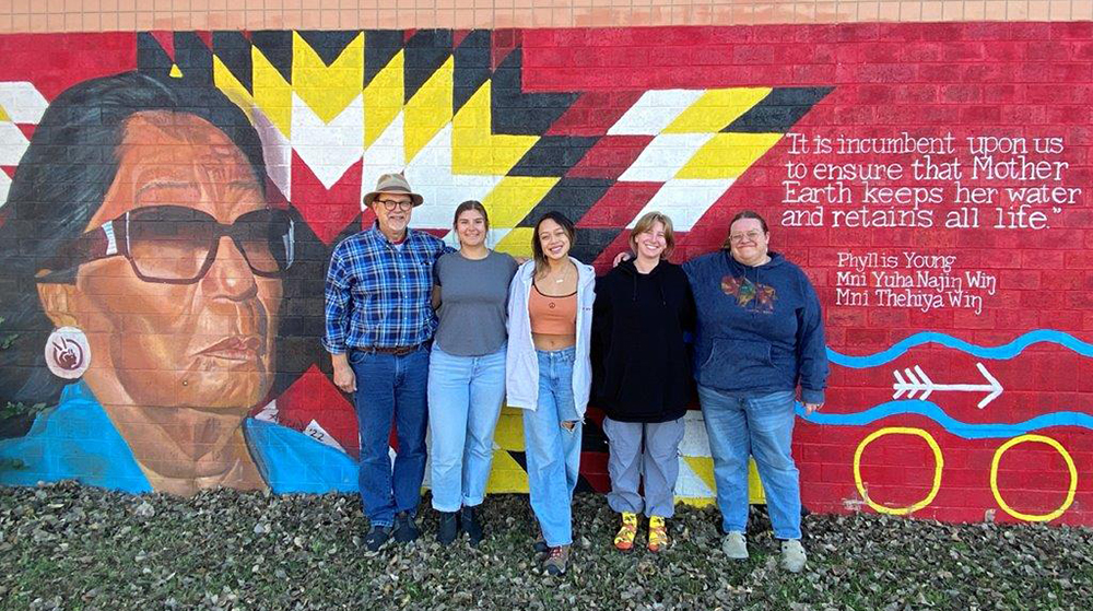 students in front of a mural at Standing Rock