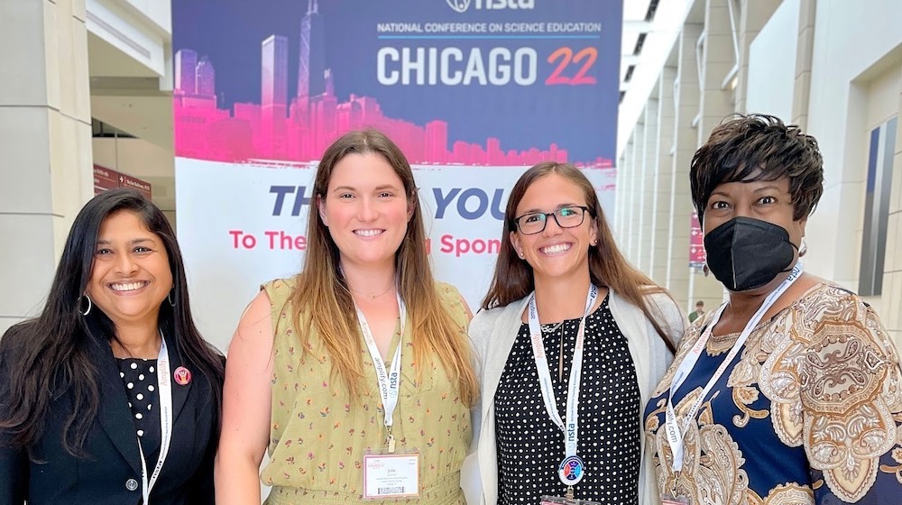 Four women, all Loyola University Chicago CSME representatives, stand in front of the National Science Teaching Association Conference banner. Four women, all Loyola University Chicago CSME representatives, stand in front of the National Science Teaching Association Conference banner.
