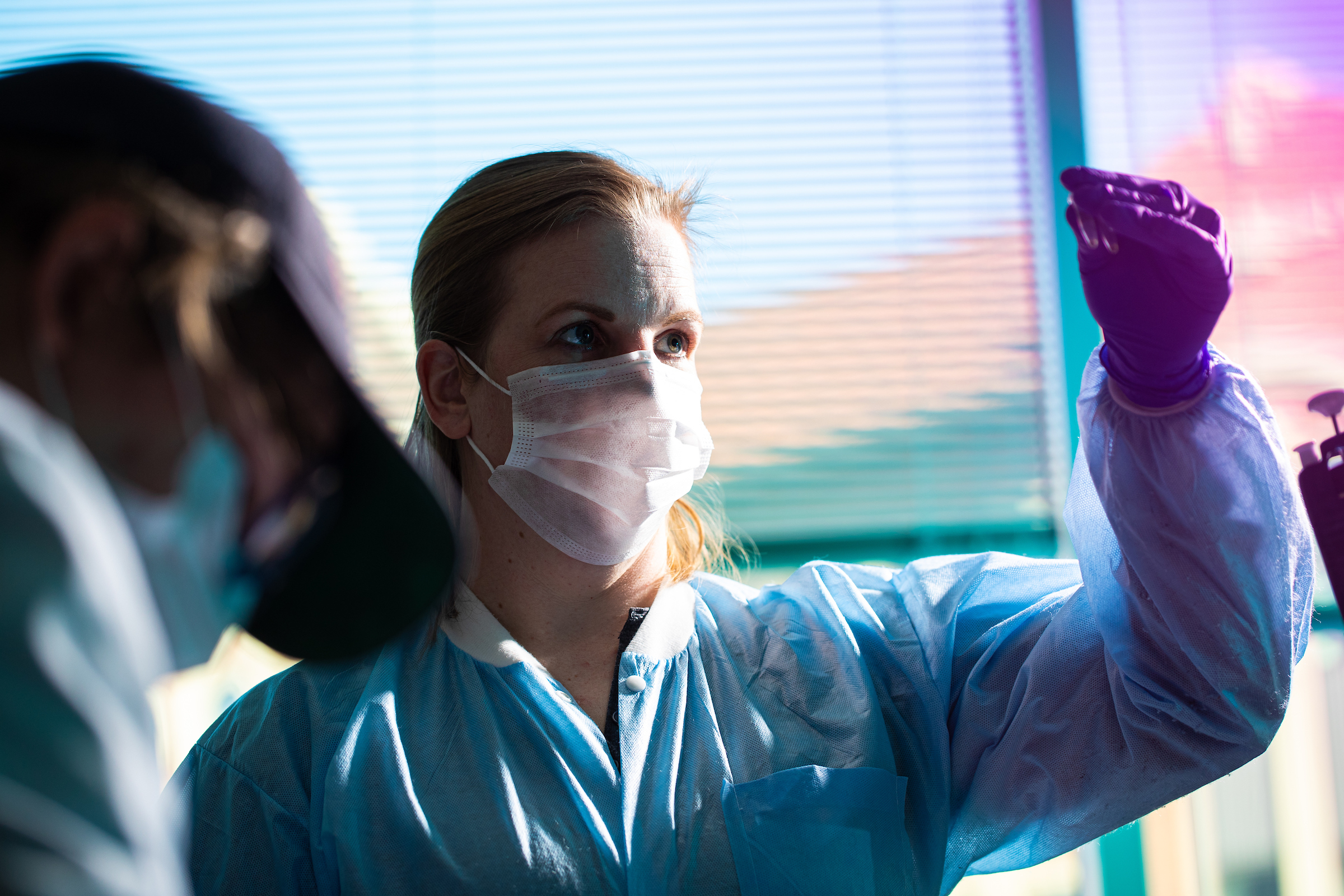 A female is looking at tubes she is holding on one hand.