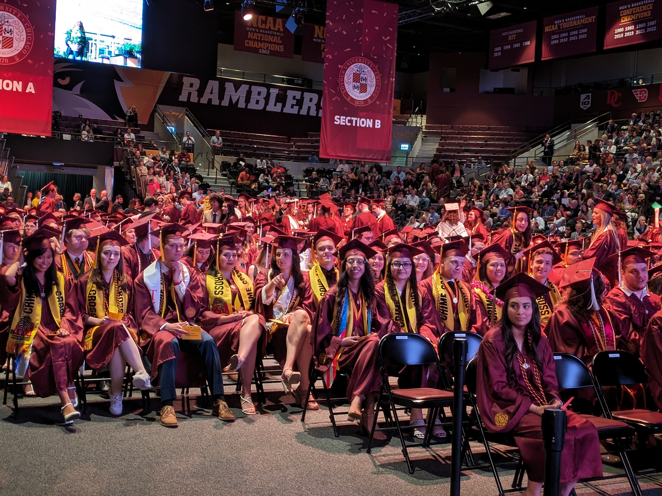 A group of graduates in caps and gowns sitting for the commencement ceremony