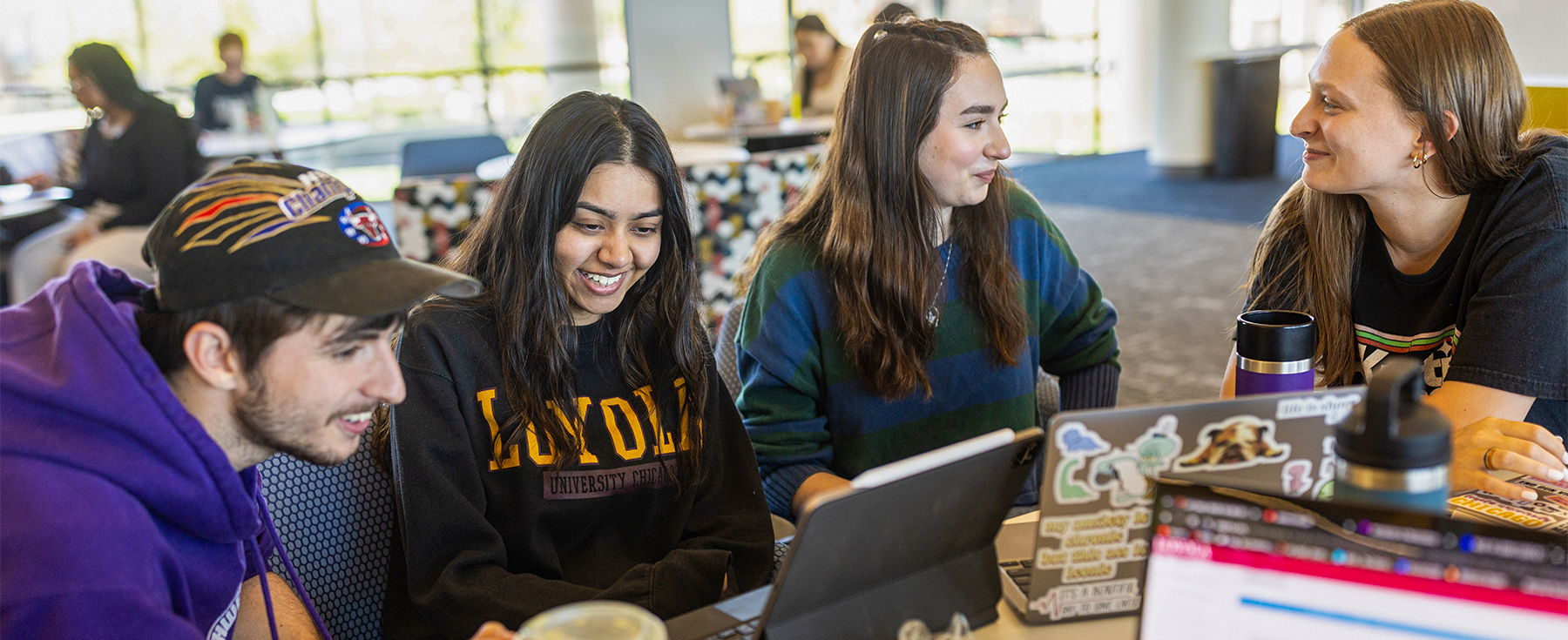 Loyola students work together on lap tops