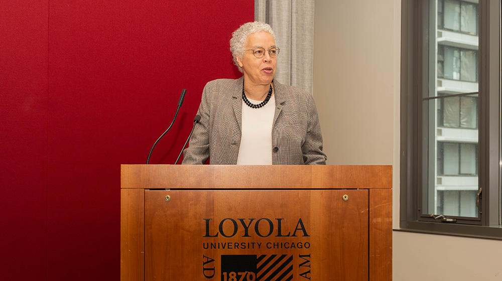 Toni Preckwinkle delivers a speech behind a podium reading Toni Preckwinkle delivers a speech behind a podium reading
