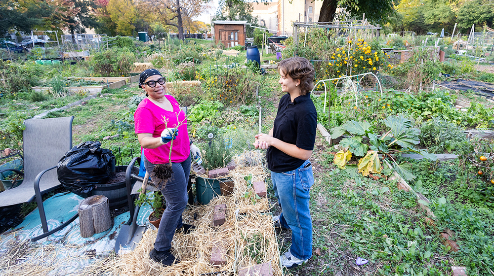 Emma Pierce talks with gardener Cynthia Anglin in the Woodlawn neighborhood comm