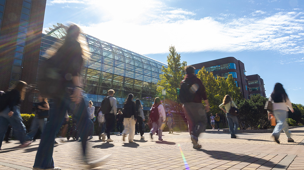 SES building exterior with student walking on the plaza