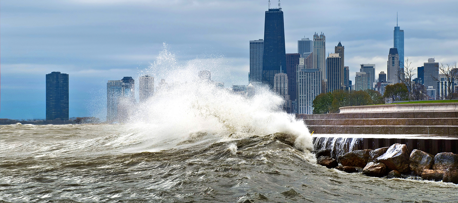 waves crashing on the shore in Chicago with the skyline in the background