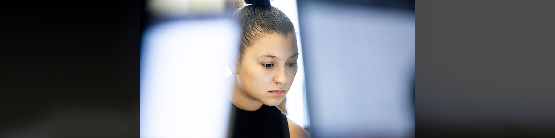 A young woman working on a computer in a Loyola University Chicago classroom